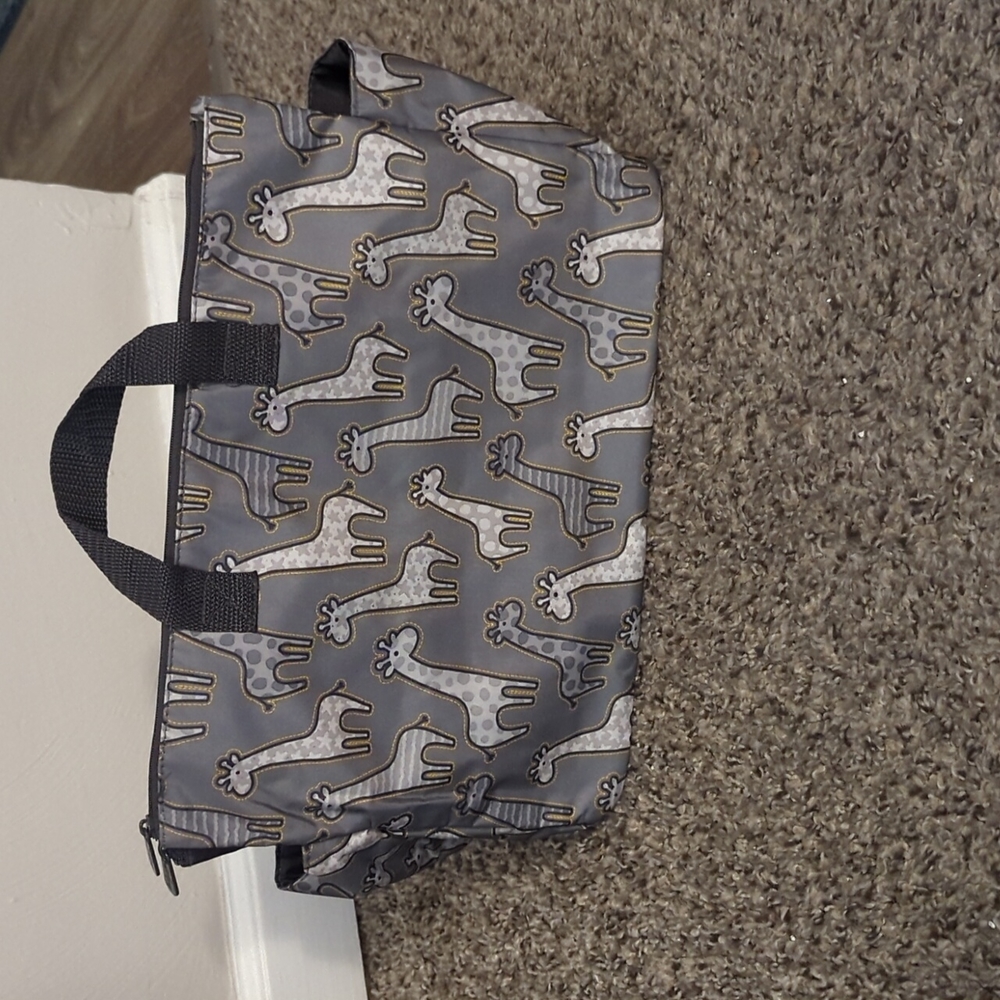 Thirty-one. Giraffe print diaper bag with two zipper pockets and a middle pouch.